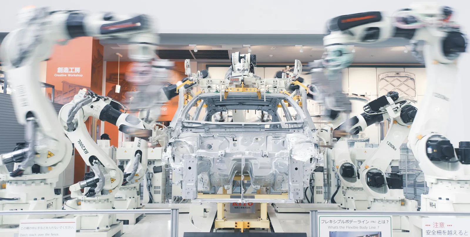 Robotic arms assembling a car chassis on an automated production line